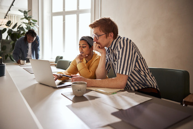 Two people working on a laptop together