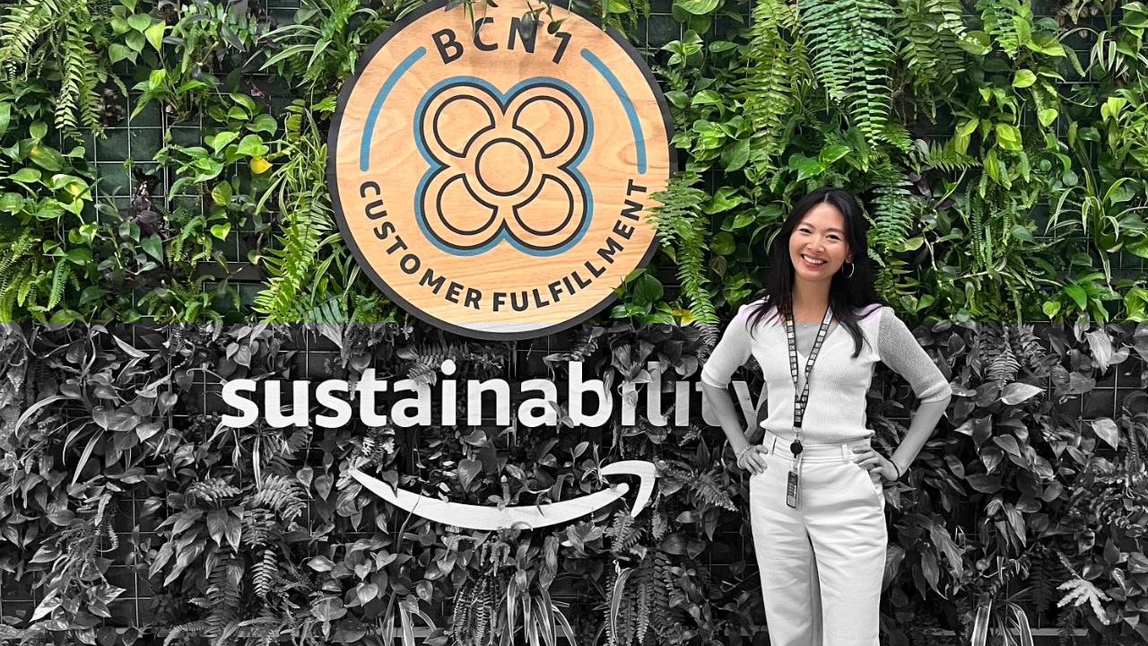 Hilary Tam standing in front of a wall with a sign that says 'sustainability'