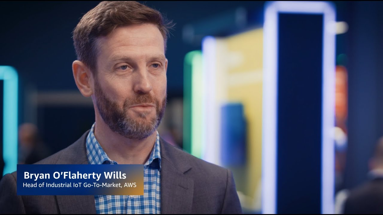 YouTube thumbnail image of Bryan O'Flaherty Wills, Head of Industrial IoT Go-To-Market at AWS, in a professional setting with blurred background.