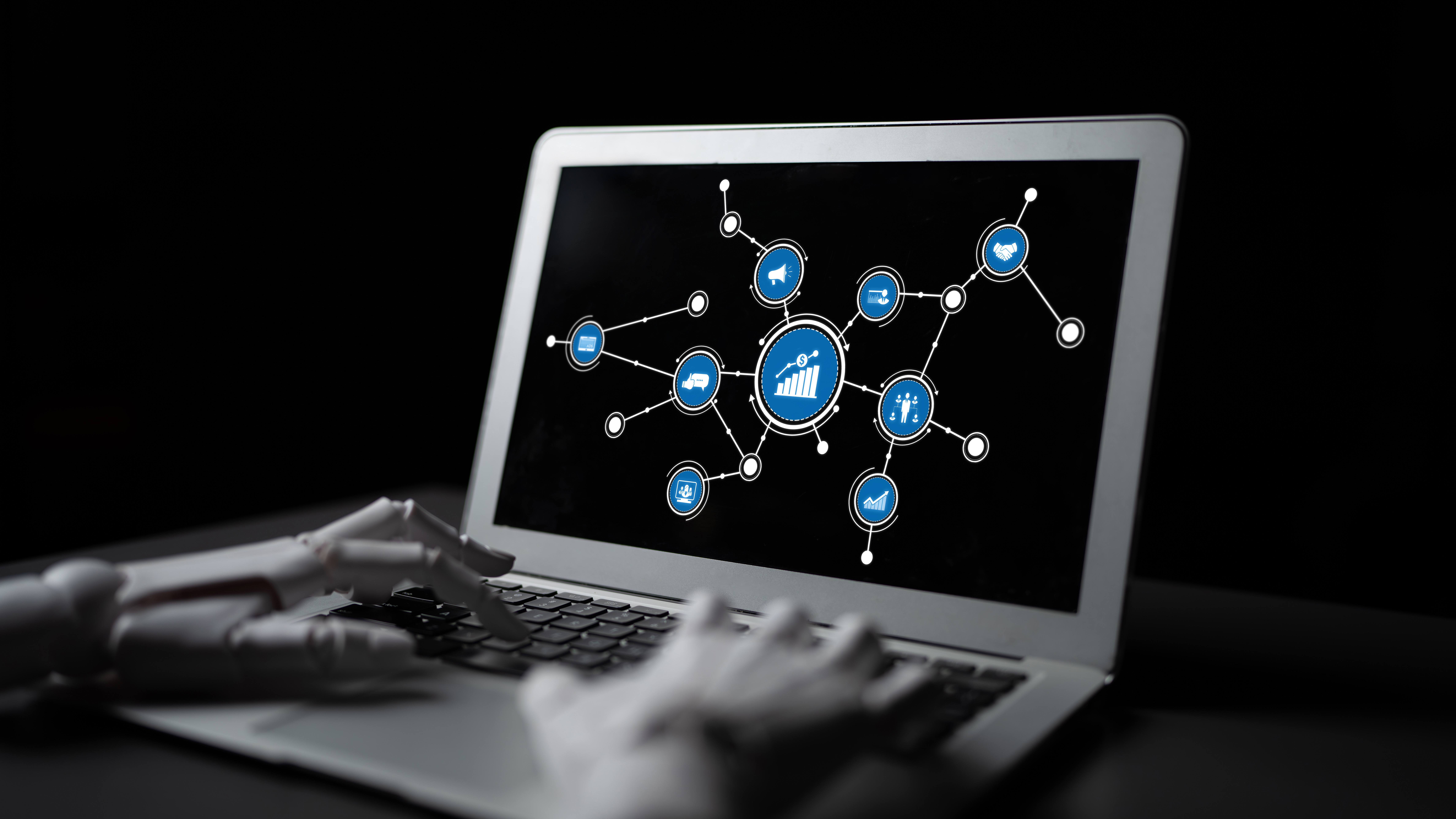 A robotic hand types on a laptop displaying a digital interface with graphs and icons, symbolizing the integration of technology and data analytics in modern workspaces. Tessel