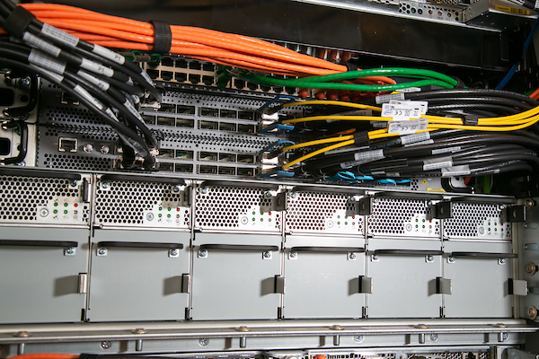 Close-up of server hardware with colorful network cables connected to ports and metal components.