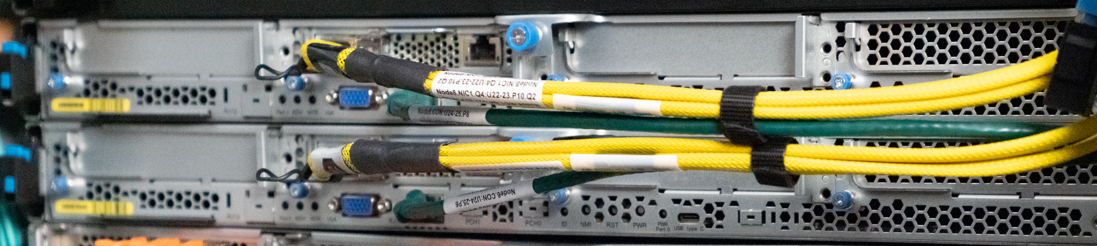 Close-up of server hardware with yellow and green network cables connected to the ports.