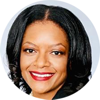 Portrait of a smiling woman with black hair, wearing a dark top, shown against a light background.