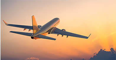 An airplane flying in the sky during sunset with clouds and sun rays in the background.