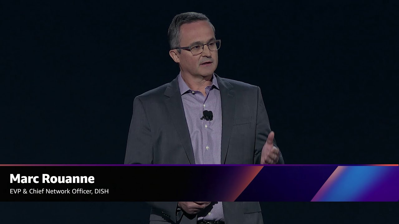 Marc Rouanne, EVP & Chief Network Officer at DISH, speaking on stage during a presentation, as shown in a YouTube thumbnail image.