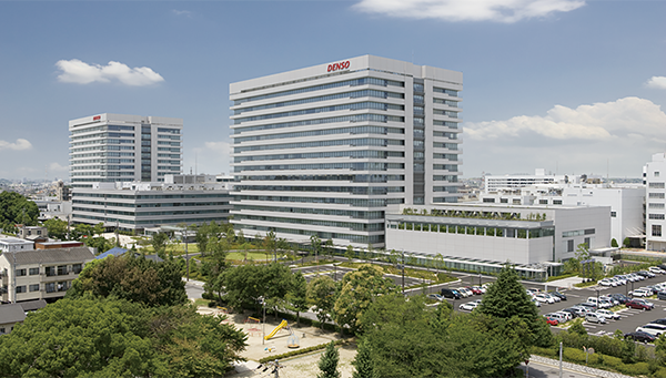 Exterior view of the DENSO headquarters buildings, surrounded by greenery and parking, as used in an AWS case study.