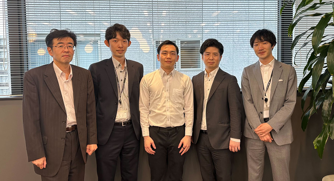 A group photo of five team members from Toda Kensetsu standing together in business attire in an office setting, used for an AWS solution case study.