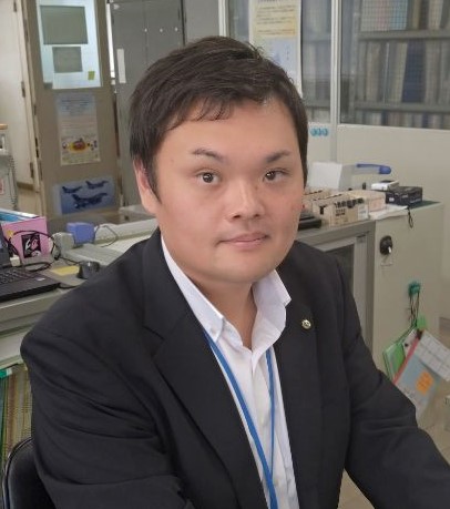 A portrait of a person in business attire seated in an office environment, used for the Misawa case study.