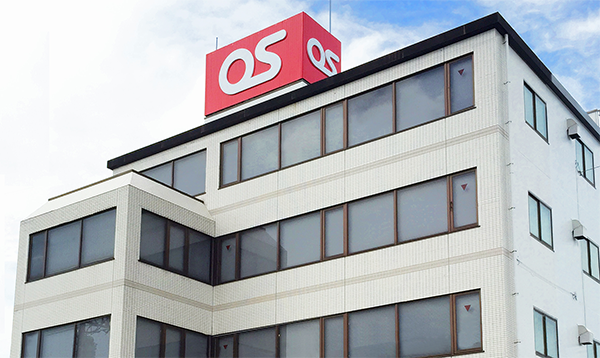Exterior view of the OS Corporation office building with a red and white OS logo sign on the rooftop.