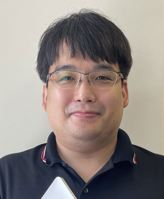 Portrait of a WonderPlanet case study speaker in glasses and a dark shirt, facing forward with a neutral expression against a light background.